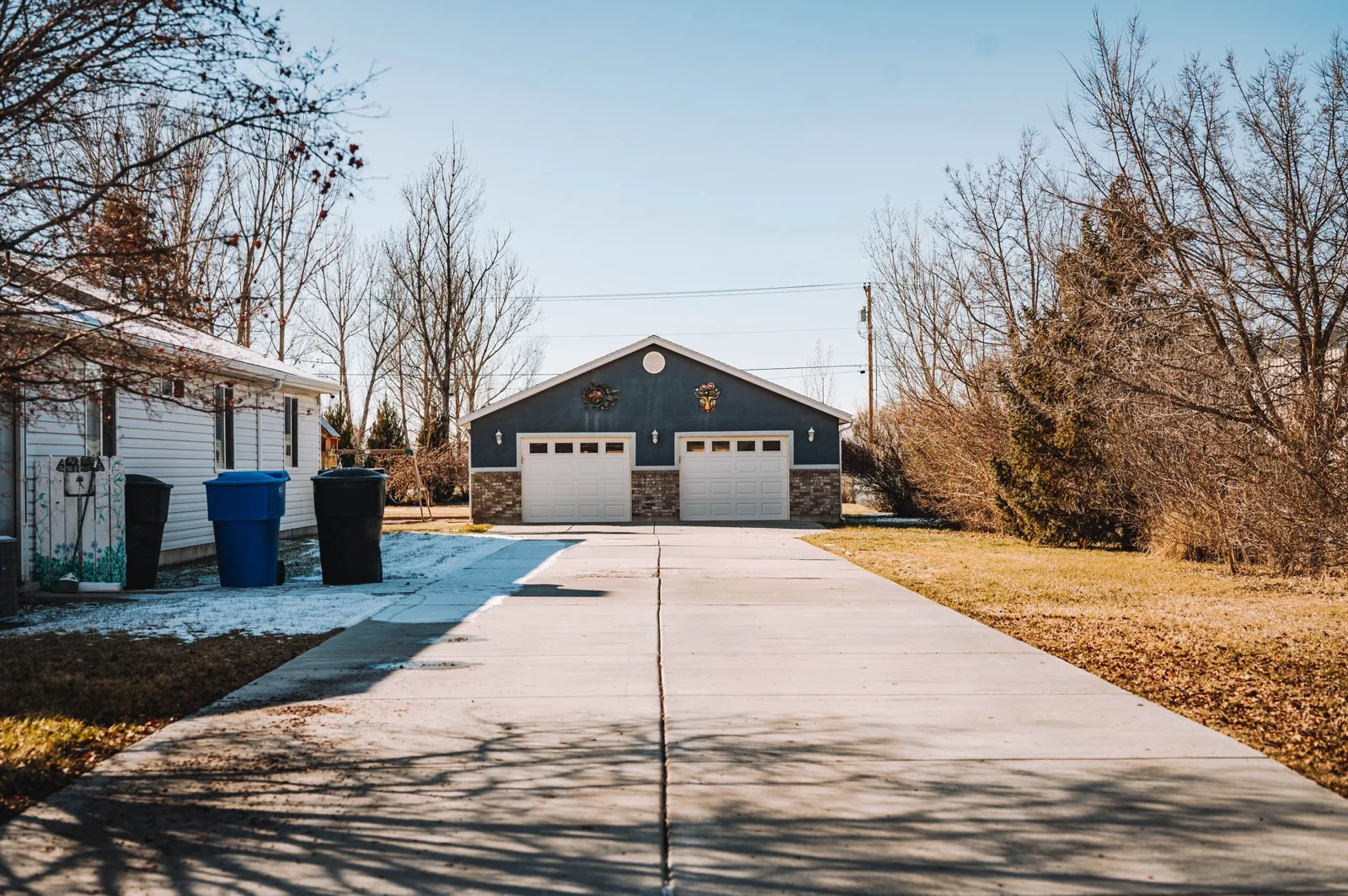 A detached garage under construction with framing and roofing complete